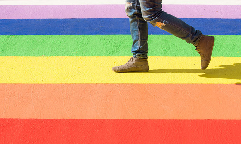 Legs Walking On Rainbow Painted Road